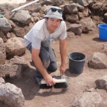 A volunteer brushing the surface in area F (Tal Rogovski)